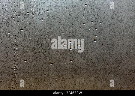 Wassertropfen und Kondensation an einem Fenster. Stockfoto