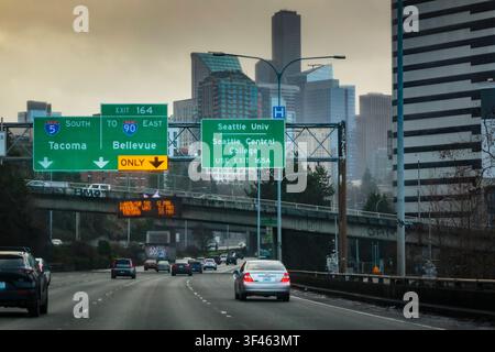 Interstate 90 im Innenstadtbereich von Seattle, Verkehr auf der Autobahn, Verkehrsschilder über der Straße, Dämmerung. Stockfoto