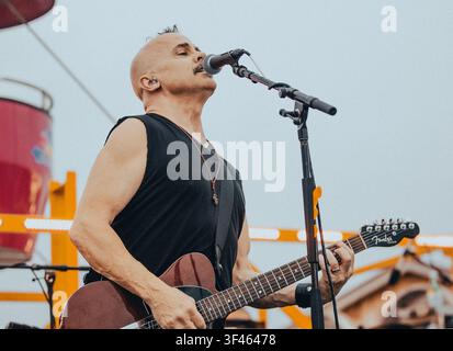 Leidenschaftlicher männlicher Musiker singt und spielt Gitarre Stockfoto