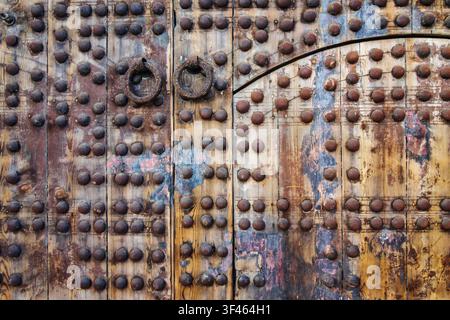 Ein hölzerner Türrahmen in einem alten Gebäude mit Metallnieten, Nahaufnahme Stockfoto