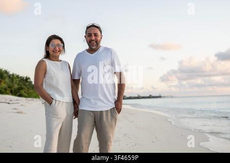 Lächelndes Paar mittleren Alters genießt Beachurlaub Stockfoto