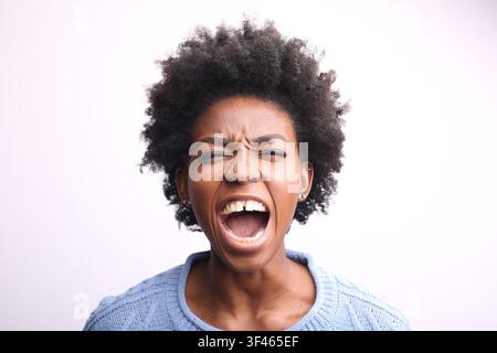 Frustrierte junge schwarze Frau schreit laut Stockfoto