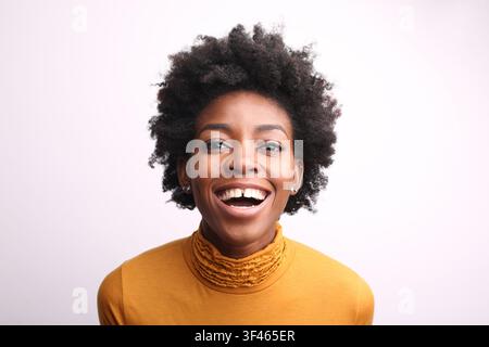 Glückliche junge schwarze Frau mit Afro-Haaren lächelt Stockfoto