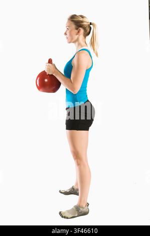 Frau steht mit Kettlebell vor der Goblet-Squat-Position Stockfoto