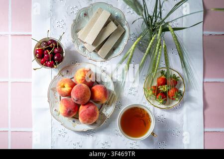 Sommerfrüchte-Tee und Waffeln auf Spitzentuch. Natürliche Lebensmittel Stockfoto