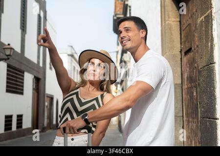 Touristenpaar geht mit Gepäck durch die historische Altstadt im Urlaub Stockfoto