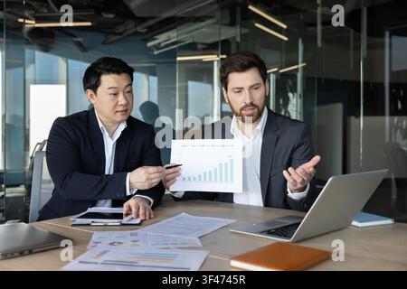 Zwei verschiedene Geschäftsleute arbeiten während einer Bürositzung zusammen Stockfoto