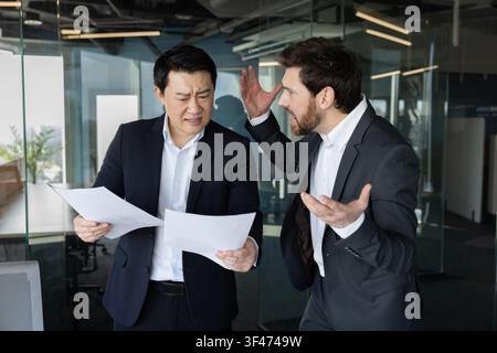 Geschäftsleute führen eine hitzige Diskussion und erleben einen Streit, zeigen Konflikt, Wut und Stress während eines schwierigen Gesprächs in einer modernen Büroumgebung Stockfoto