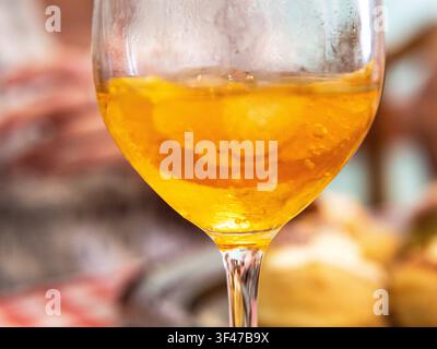 Oranger Aperitif-Cocktail mit Eis und Zitronenscheiben in einem Weinglas. Stockfoto