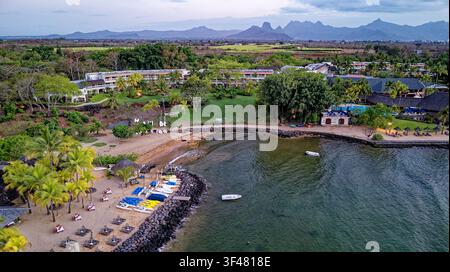 Luftbild, das eine schöne Küsten-strandresort-Anlage entlang einer ruhigen Meeresbucht in Mauritius zeigt. Das Bild fängt mehrere moderne mehrstöckige Ho Stockfoto