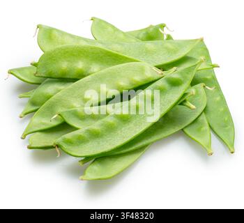Ein loser Haufen frischer, junger grüner Schneeerbsen in Schoten, isoliert auf weißem Hintergrund. Clipping Path. Stockfoto