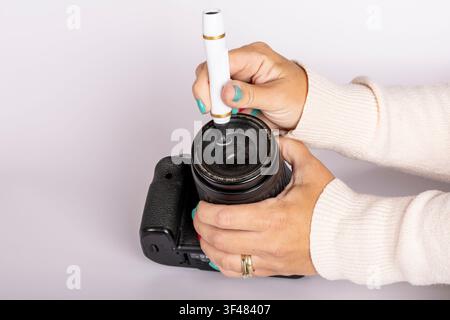 Reinigung der Kameralinse mit einem Linsenstift Stockfoto
