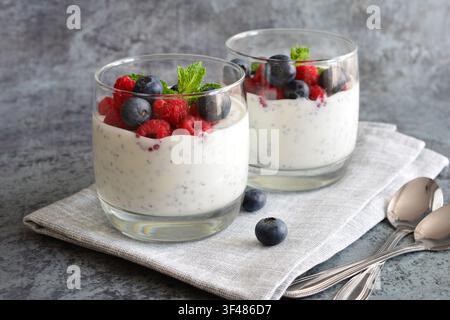 Cremiges Dessert mit frischen Beeren in Glasbechern auf Serviette Stockfoto