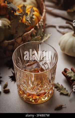 Bourbon mit Eis und Zimt auf einem gemütlichen Thanksgiving-Tisch.. Stockfoto
