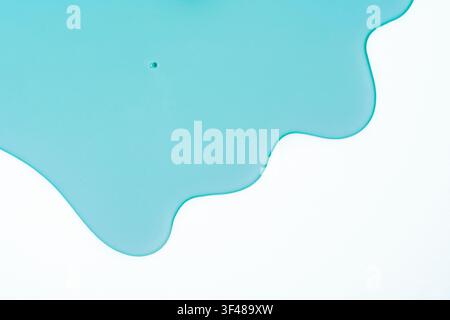 Heller türkiser Gelabstrich, der sich auf einem sauberen weißen Hintergrund ausbreitet, mit glänzenden Flecken, weichen Verschmierungen und fließenden Kanten für moderne abstrakte Schönheit Stockfoto