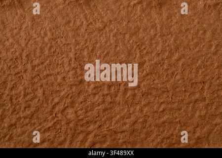 Nahaufnahme von braunem Kraftpapier mit rauer, gefurchter Verpackungstextur und sichtbaren Fasern. Natürlicher recycelter Kartonhintergrund, ideal für Verpackungs-Mockups Stockfoto