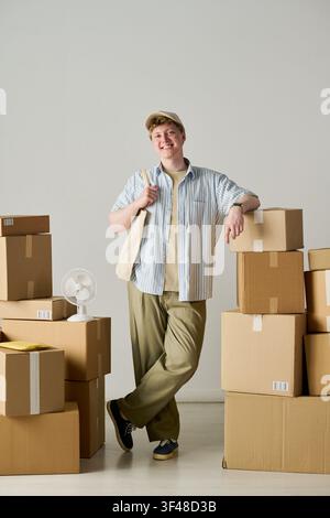 Porträt eines jungen Erwachsenen Mannes, der mit Umzugskartons für einen Umzug steht Stockfoto