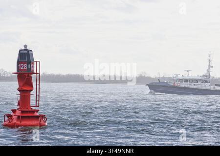Polizeiboot, das eine rote Navigationsboje auf offenem Wasser passiert   Ein Einsatzboot der Strafverfolgung navigiert auf offenem Wasser an einer großen roten Navigationsboje vorbei Stockfoto
