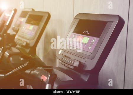Cardio-Zone mit Trainingsgeräten in einem sonnendurchfluteten Fitnessstudio, selektive Schärfentiefe Stockfoto