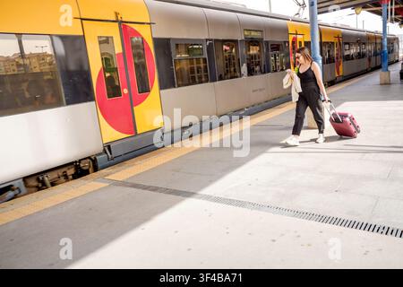 Porto, 17. Juni 2022: Frau Reisende geht mit Gepäck auf einem Bahnhofsgleis, bereit zur Abreise. Stockfoto