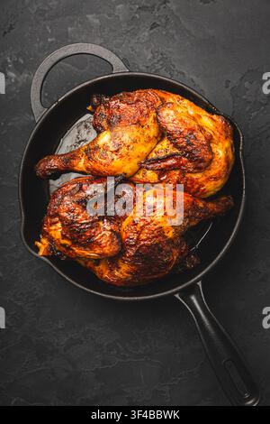 Saftige und knusprige gebratene Hähnchenschenkel in einer Gusseisenpfanne Stockfoto