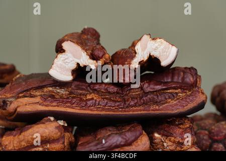 Nahaufnahme von traditionell geräuchertem Schweinebauch und Speck mit geschnittenen Scheiben, die Fleischschichten, Fett und goldenbraune knusprige Haut zeigen. Präsentation von gepökeltem Fleisch Stockfoto