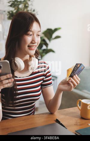 Glück Unternehmer schönes Geschäft asiatische junge Frau tragen lässig Handy zum Einkaufen online genießen Sie mit sozialen Medien und Laptop zu Hause Stockfoto