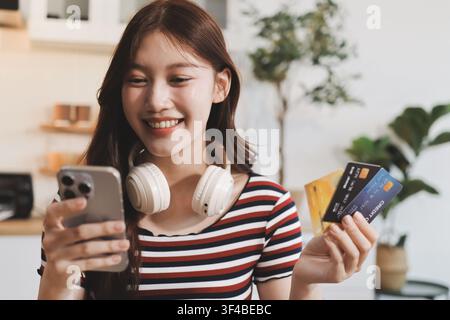 Glück Unternehmer schönes Geschäft asiatische junge Frau tragen lässig Handy zum Einkaufen online genießen Sie mit sozialen Medien und Laptop zu Hause Stockfoto