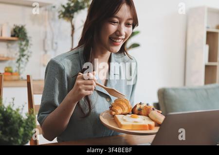 Glück Unternehmer schönes Geschäft asiatische junge Frau tragen lässig Handy zum Einkaufen online genießen Sie mit sozialen Medien und Laptop zu Hause Stockfoto