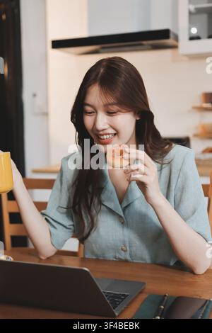 Glück Unternehmer schönes Geschäft asiatische junge Frau tragen lässig Handy zum Einkaufen online genießen Sie mit sozialen Medien und Laptop zu Hause Stockfoto