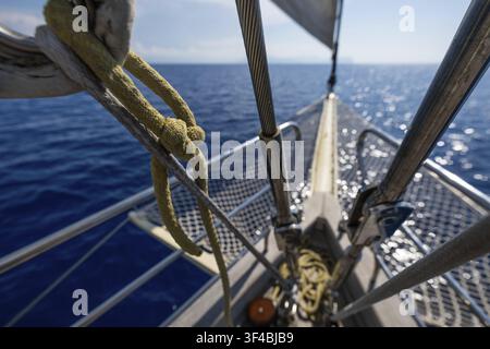 Blick über den Bug eines Segelboots auf ein hellblaues Meer unter einem blauen Himmel, Äolische oder Liparische Inseln, Sizilien, Süditalien, Italien Stockfoto
