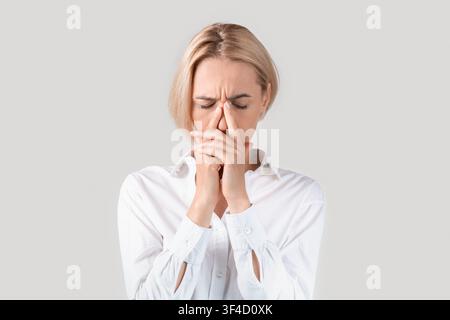 Reife Geschäftsfrau leiden unter Stress, Erschöpfung oder Kopfschmerzen auf hellem Hintergrund Stockfoto