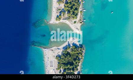 Eine Luftaufnahme von oben zeigt eine baumbedeckte Halbinsel, sandige Buchten und klares blaues Wasser am Lagoon Beach in Kassandra, Griechenland. Stockfoto
