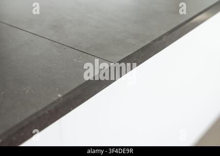 Eine detaillierte Ansicht einer modernen dunkelgrauen Steinoberfläche, die ihre Textur und die präzise Naht zwischen zwei Abschnitten hervorhebt Stockfoto