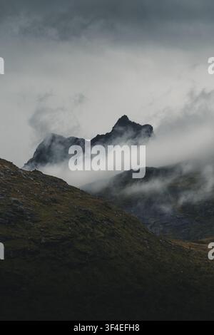 Blick auf die dramatischen, wolkenbedeckten Gipfel der Lofoten-Berge in Nordland, Norwegen. Stockfoto