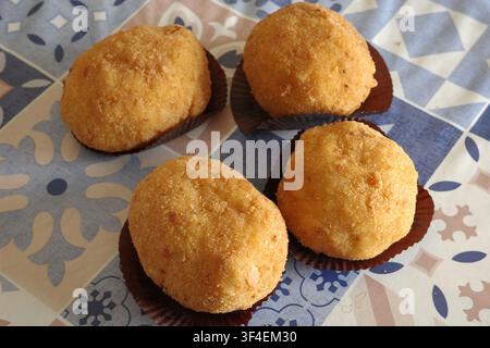 Traditionelle sizilianische Reisbällchen (Arancini) serviert auf einem gemusterten Tisch Stockfoto