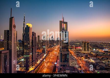 Erhöhte Sonnenuntergangsansicht des Verkehrs auf der Sheikh-Zayed-Straße und der Wolkenkratzer, einschließlich des Burj Khalifa in Dubai, Vereinigte Arabische Emirate. Stockfoto
