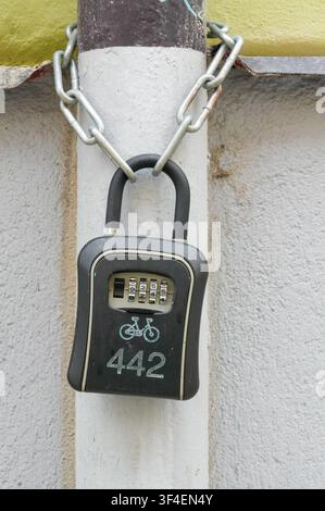 Vorhängeschloss an einer weißen Wand mit Kette, Sicherheits- und Sicherheitskonzept Stockfoto