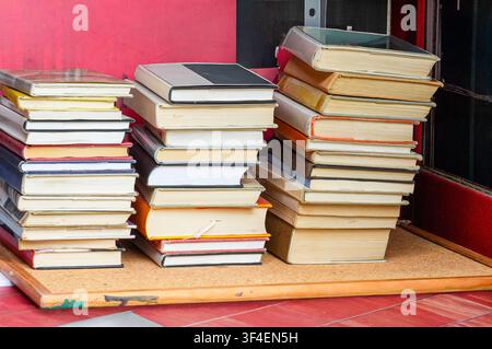 Stapel alter Bücher auf einem Tisch vor der Bibliothek Stockfoto