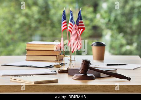 Amerikanisches Rechtssystem mit Richterschläger, Waage der Gerechtigkeit und US-Flaggen auf einem Holzschreibtisch Stockfoto