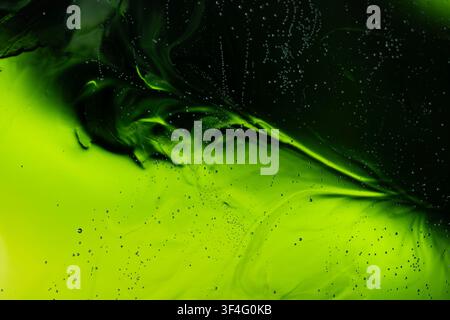 Grüne Flüssigkeit mit Blasen, die ein abstraktes fließendes Hintergrundmuster erzeugen Stockfoto