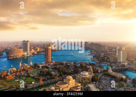 Ein atemberaubender panoramischer Luftbild-Drohnenblick auf die Stadtlandschaft von Kairo während eines lebendigen goldenen Sonnenuntergangs. Die Fotografie fängt moderne Wolkenkratzer ein, die sich entlang der Stockfoto