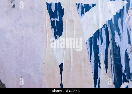 Werbetafel mit alten Plakaten. Weißer, blauer zerrissener Poster-Hintergrund in der Stadtstraße Stockfoto