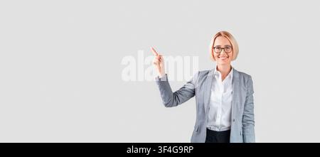 Lady Unternehmer im Business Anzug beiseite zeigt auf leeren Raum auf hellen Studio Hintergrund Stockfoto