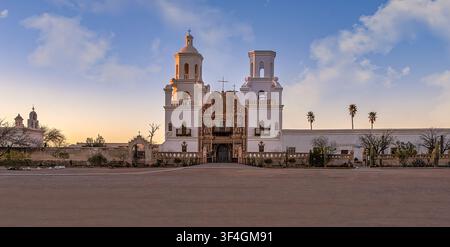 Mission San Xavier del Bac in der Nähe von Tucson, Arizona, im warmen Abendlicht, mit ihrer weißen Stuckfassade, den beiden Glockentürmen und dem verzierten Eingang. Stockfoto