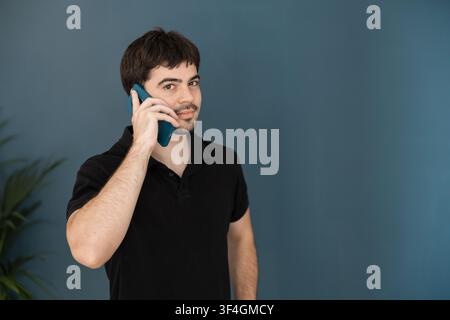 Mann mit Poloshirt telefoniert am Smartphone Stockfoto
