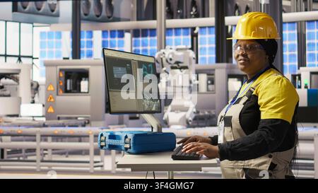 Porträt einer lächelnden Frau in einem Industrie-4.0-Solarzellenwerk, das erneuerbare Energie produziert. Fröhlicher Ingenieur in einer Photovoltaik-Smart-Fabrik, der Daten analysiert, Systemmetriken überprüft, Kamera A Stockfoto