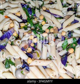 Ein Pasta-Salat im mediterranen Stil mit Penne-Nudeln, Kichererbsen, Pilzen, Kohl und rotem Kohl. Stockfoto