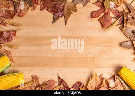 Holz-Hintergrund mit gefallenen Blättern, Weizen und Mais für Herbstkonzepte Stockfoto