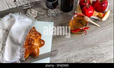 Jüdisches Neujahrsfest mit traditionellen Speisen, einer Menora und Wein Stockfoto